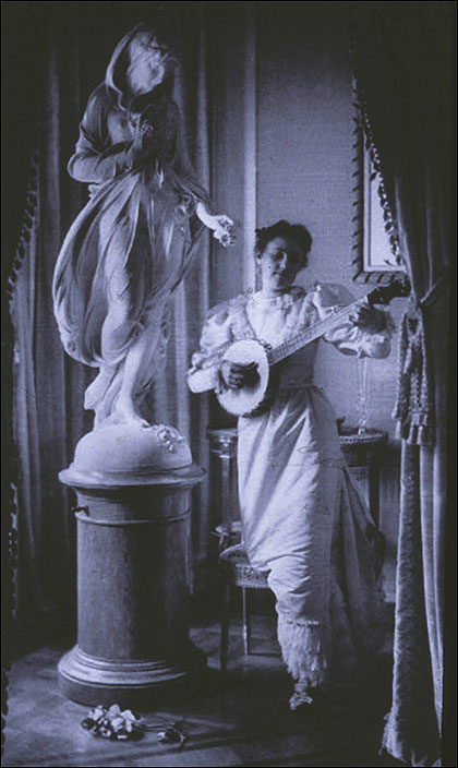 Miss Apperson playing banjo beside statue of Flora in niche of Sen. George Hearst's residence, Washington, D.C. The photograph  in 1895 by Frances Benjamin Johnston.jpg